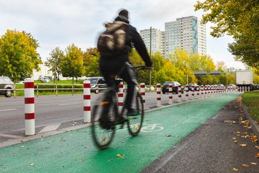 Fahrradfahrer auf einem mit Pollern vom Autoverkehr getrennten Radweg
