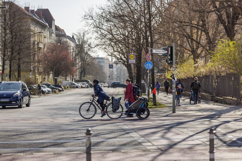 Fahrradfahrerin mit Fahrradanhänger auf einer Kreuzung in Berlin-Friedrichshain