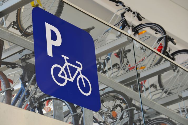 Blick in die obere Etage eines Fahrradparkhauses zu Fahrradabstellanlagen mit einem blauen Fahrradparken-Schild.