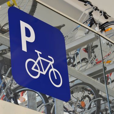 Blaues Schild mit weißem Fahrradparken-Symbol