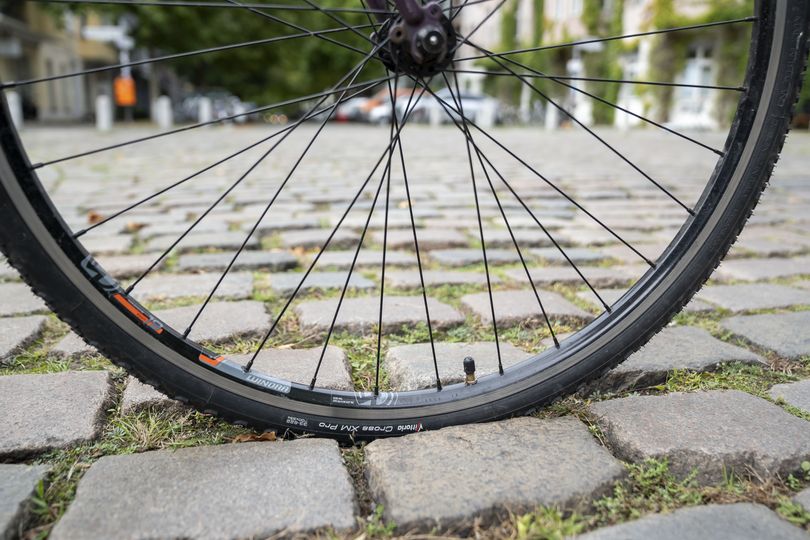 Nahaufnahme eines Fahrradreifens auf einer Kopfsteinpflaster-Straße