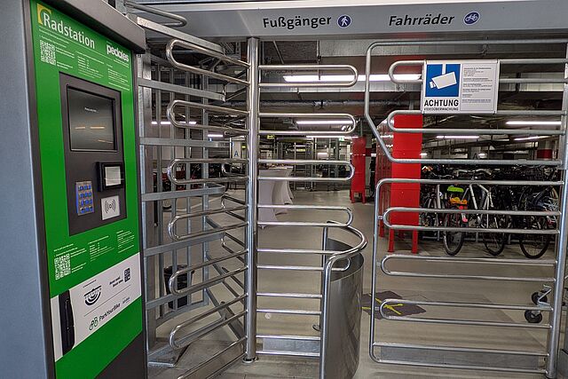 Eingangsbereich zum gesicherten Fahrradparken mit Terminal und Drehkreuz