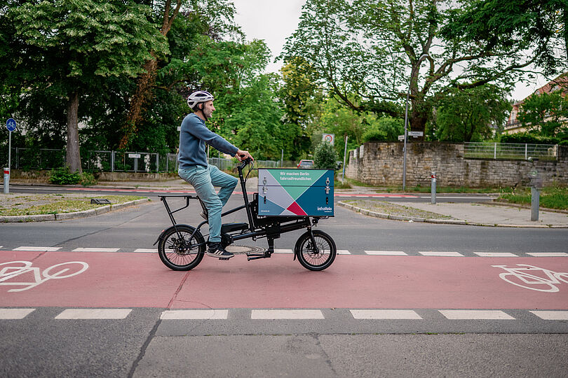 Lastenradfahrer auf rotmarkiertem Radfahrstreifen