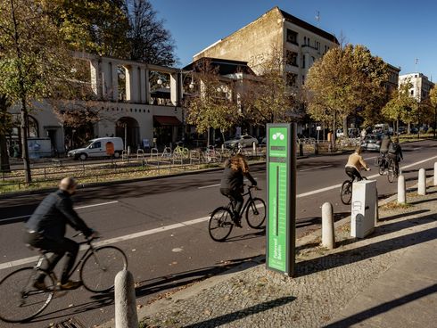 Radfahrer_innen radeln am Fahrradbarometer auf der Schönhauser Allee vorbei 