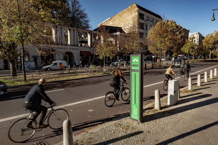 Radfahrer_innen radeln am Fahrradbarometer auf der Schönhauser Allee vorbei