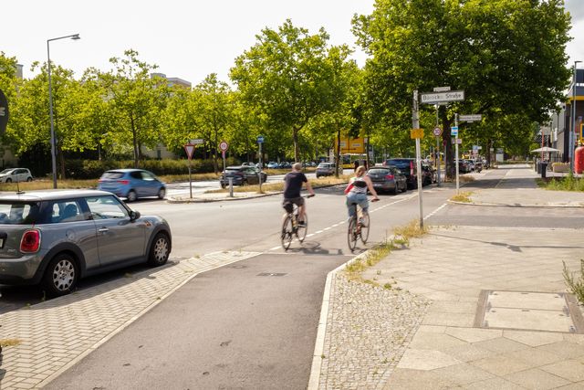 Fahrradfahrer fahren auf einem Hochbordradweg bei sonnigem Wetter