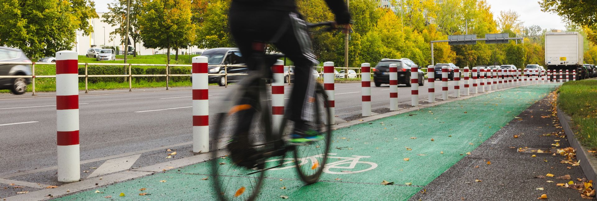 Radfahrer auf einem geschützten Radfahrstreifen, der mit grüner Farbe beschichtet ist.