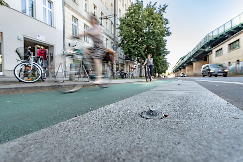 Bord mit Glasmarker neben Radfahrstreifen