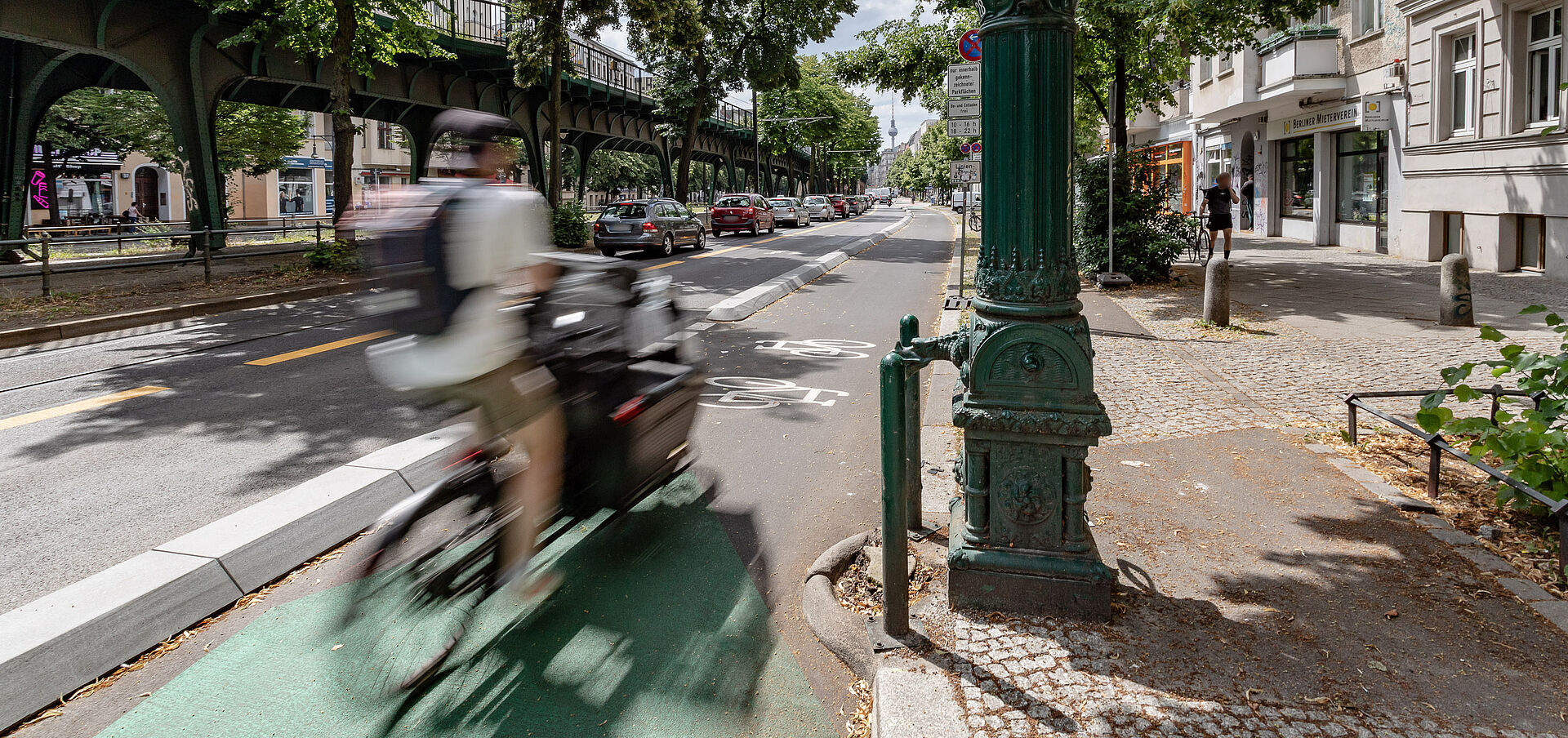 Fahrradfahrer fährt auf geschütztem radfahrstreifen auf der Schönhauser Allee