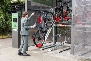 Ein Mann stellt sein Fahrrad in einer Sammelschließanlage ein