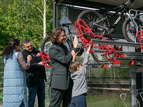 Mehrere Personen testen zusammen mit Kindern die Doppelstockparker der Fahrradabstellanlage