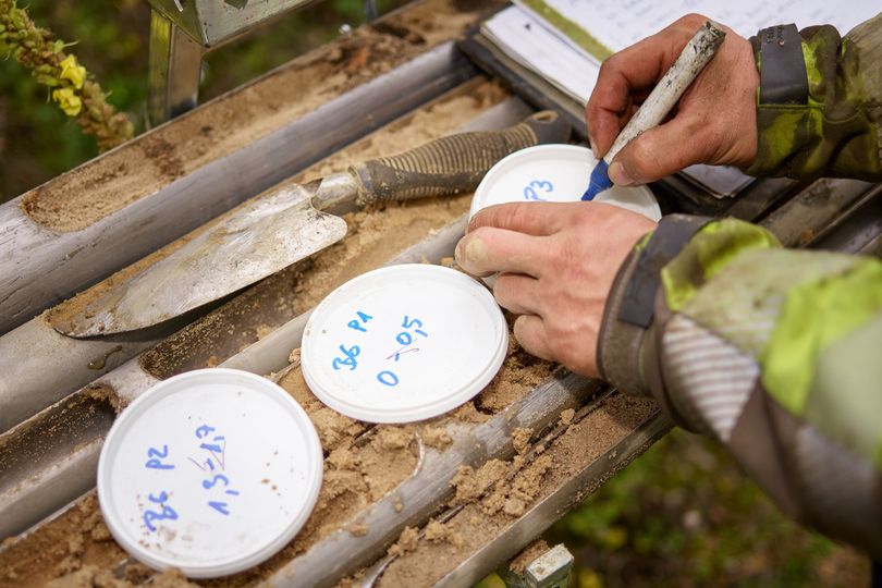 Der Gutachter beschriftet die Becher mit den Bodenproben.