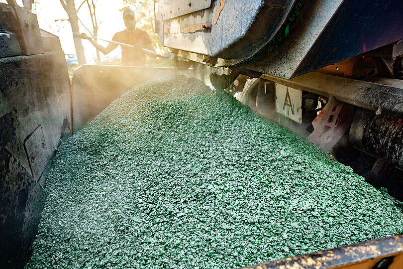 Die Asphaltmasse wird in einen Fertiger abgekippt, der die Masse in der richtigen Menge und Dicke auf dem Untergrund als neue Deckenbeschichtung einbaut.