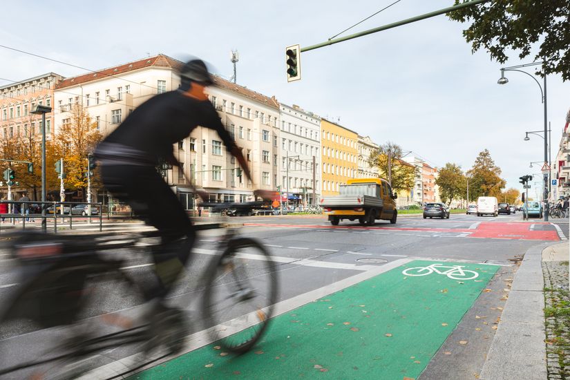 Radfahrer auf einem grün markierten Radfahrstreifen vor einer Kreuzung