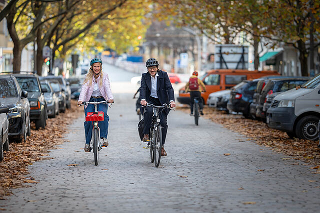 Manuela Anders-Granitzki und Michael Fugel fahren mit Fahrrädern auf der Hufelandstraße