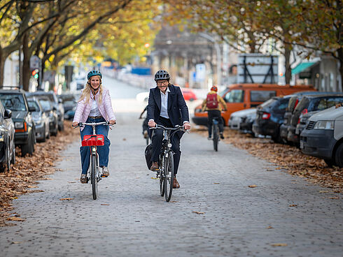 Manuela Anders-Granitzki und Michael Fugel fahren mit Fahrrädern auf der Hufelandstraße
