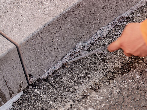 Betonborde werden auf der Straße verklebt