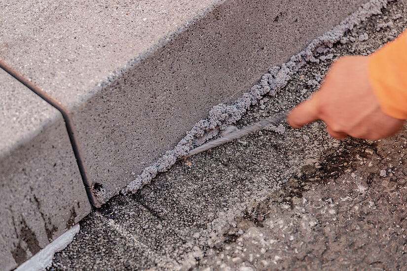 Betonborde werden auf der Straße verklebt