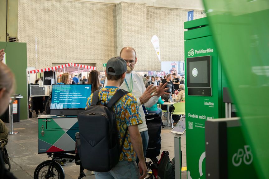 ein Mann erklärt einem anderen Mann etwas am Messestand