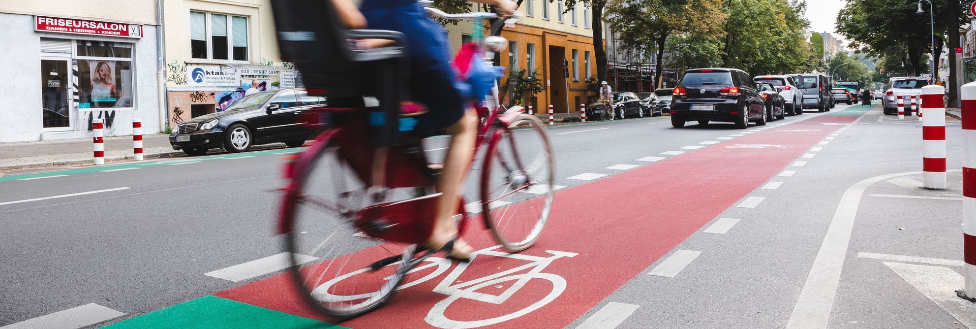 Radfahrende mit Kind auf farblich markiertem Radfahrstreifen