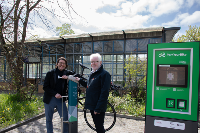 zwei Personen stehen an einer Reparaturstation für Fahrräder