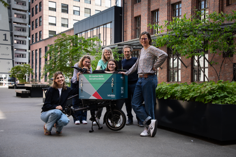 Gruppenfoto von infraVelo-Kolleg*innen mit dem neuen Lastenrad im Innehof des Ullsteinhauses