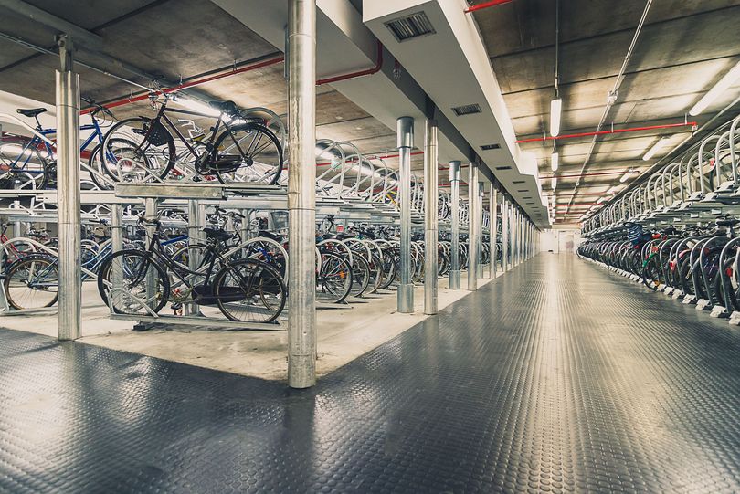 in einem Fahrradparkhaus stehen viele Fahrräder in Doppelstockparkanlagen