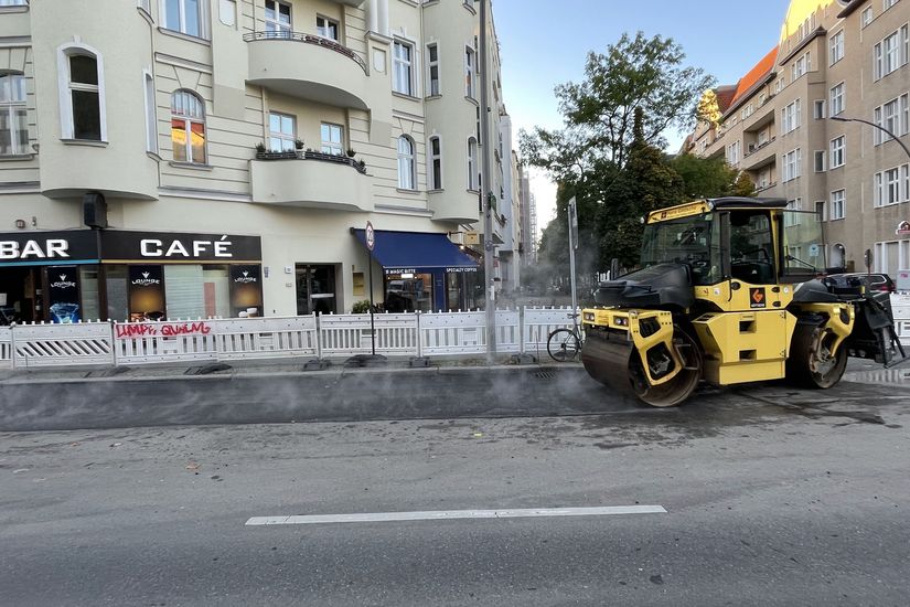 Baumaschine bearbeitet Asphalt auf einer Straße.