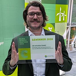 Michael Fugel hält die Auszeichnung in die Kamera