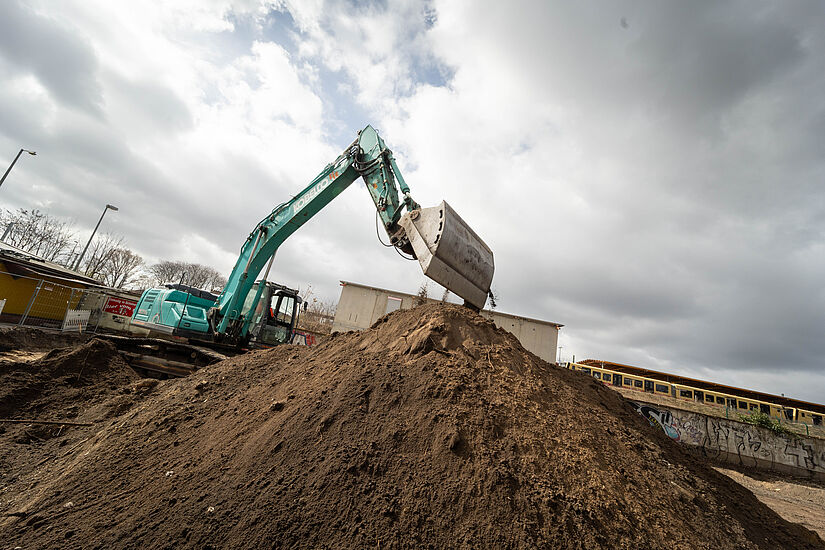 Bagger hinter einem großen Erdhaufen