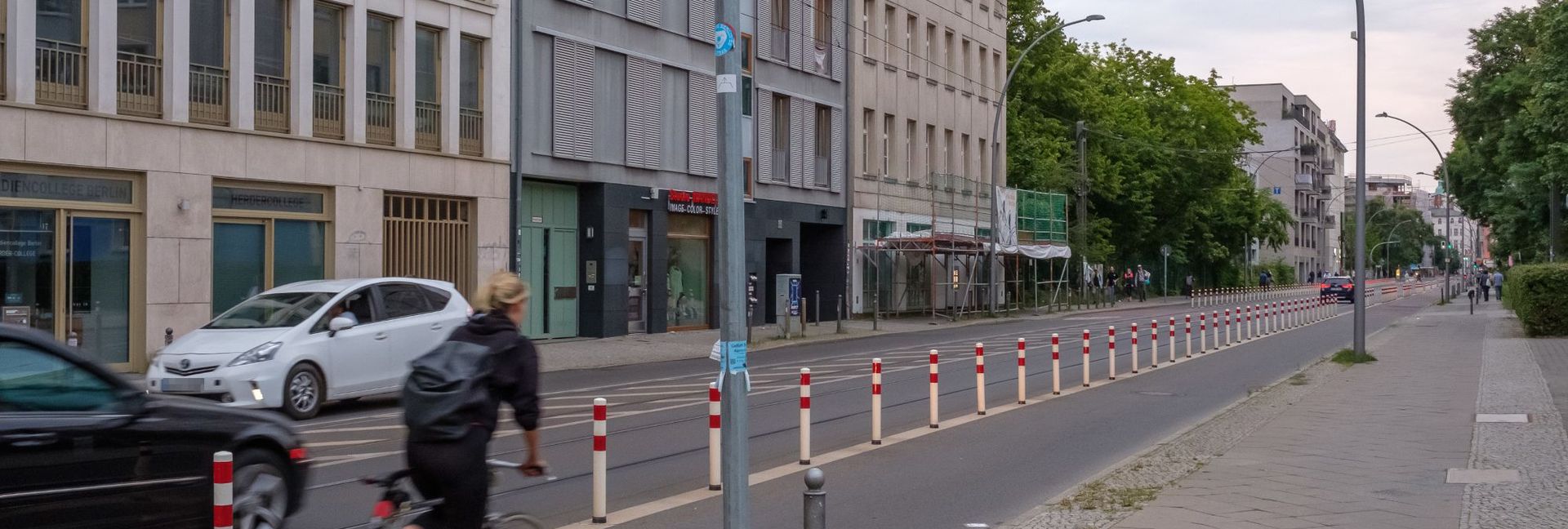 Radfahrerin fährt auf einem mit Pollern geschützten Radfahrstreifen