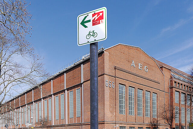 Rdwegweiser vor Backsteingebäude