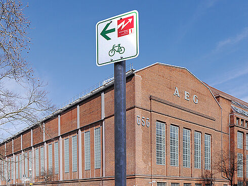 Rdwegweiser vor Backsteingebäude
