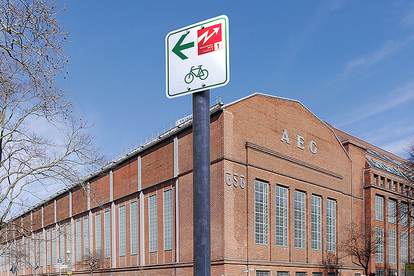 Rdwegweiser vor Backsteingebäude