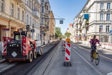 ein schweres Baugerät fräst alte Asphaltschicht ab