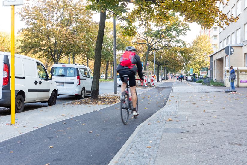 Radfahrer fährt auf Radweg vorbei an Bushaltestelle Seestraße