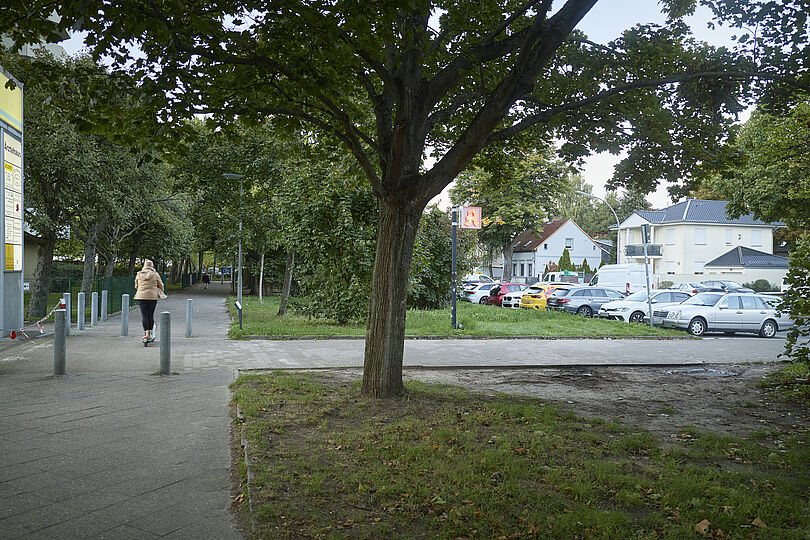 Bürgersteig ohne Radverkehrsinfrastruktur mit einer Fußgängerin.