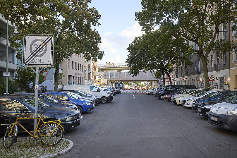 Eine Sackgasse, die zur einer Straßenbaustelle mit Bauzäunen führt.