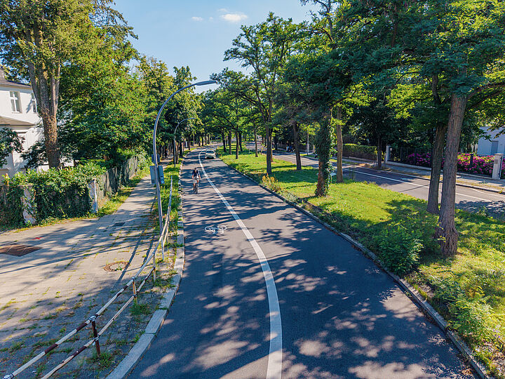 Radfahrstreifen neben einer PKW-Fahrspur und rechts im Bild ein begrünter Mittelstreifen