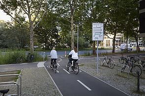 Zweirichtungsradweg mit Beschilderung und Radfahrenden.