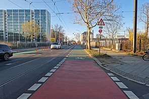 Rot und grün beschichteter Schutzstreifen auf der Siegfriedstraße entlang der Straßenbahngleise.