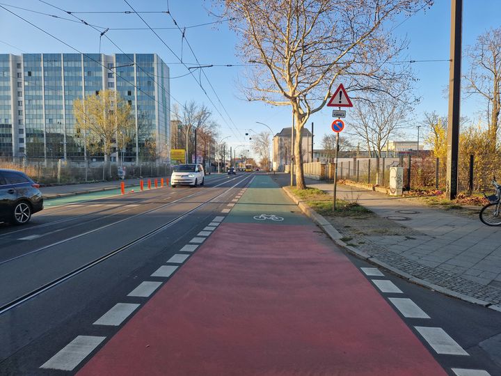 Rot und grün beschichteter Schutzstreifen auf der Siegfriedstraße entlang der Straßenbahngleise.