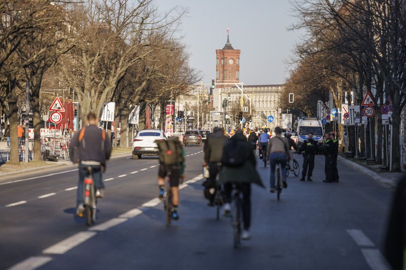 Fahrradfahrer fahren auf der Straße, im Hintergrund ist das Berliner Rote Rathaus