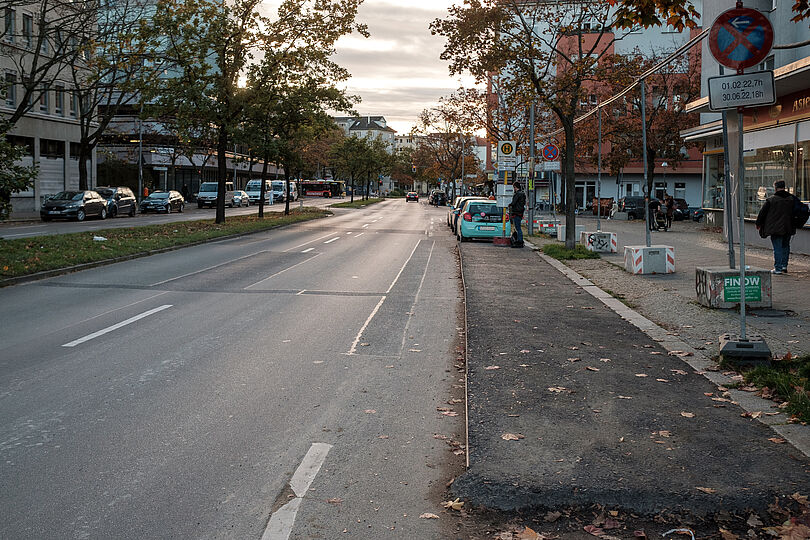 Zweispuriger Autostraße mit einer provisorischen Bushaltestelle ohne einen Fahrradweg.