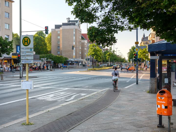Radfahrende hält an roter Ampel auf schmalem Hochboardradweg Residenzstraße