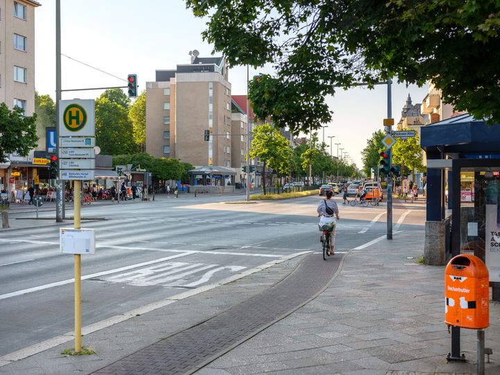 Radfahrende hält an roter Ampel auf schmalem Hochboardradweg Residenzstraße