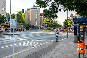 Radfahrende hält an roter Ampel auf schmalem Hochboardradweg Residenzstraße