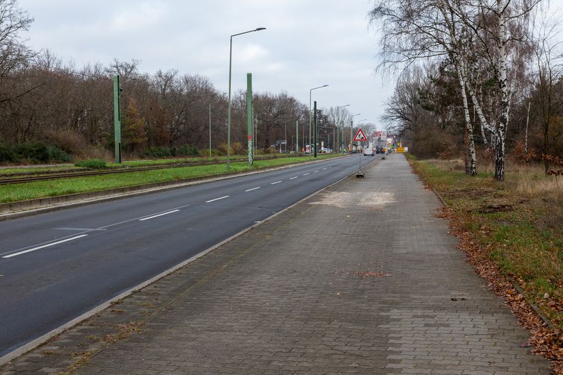 zweispurige Straße, links davon Tram-Gleise, rechts davon ein breiter Gehweg