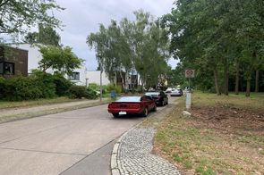 Straße mit parkenden Autos am rechten Straßenrand