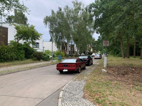 Straße mit parkenden Autos am rechten Straßenrand